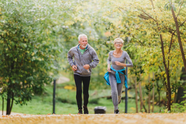 istock Smiling senior couple jogging in the park 1249852528