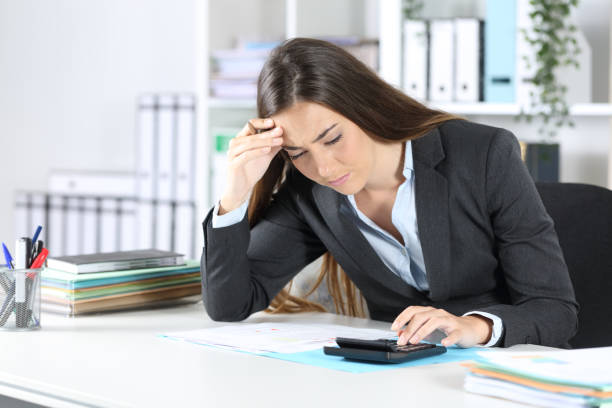 istock Worried bookkeeper checking calculator at office 1249852586