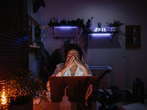 Freelancer girl works at laptop in evening