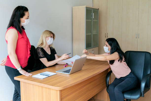 istock Business women wearing protective masks to work 1249853333