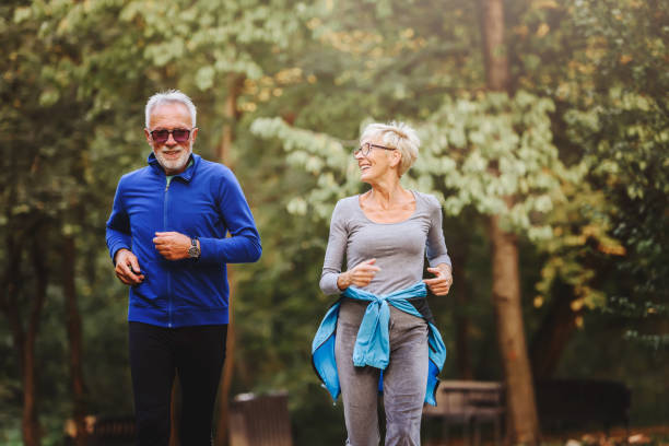 istock Smiling senior couple jogging in the park 1249853523
