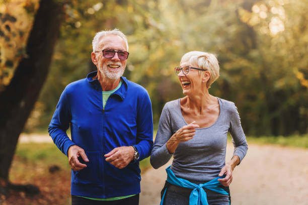 istock Smiling senior couple jogging in the park 1249853916