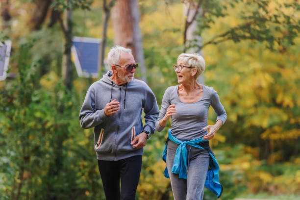 istock Smiling senior couple jogging in the park 1249854649