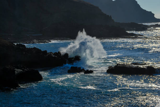 istock waves crashing on rocks, digital photo picture as a background 1249854721
