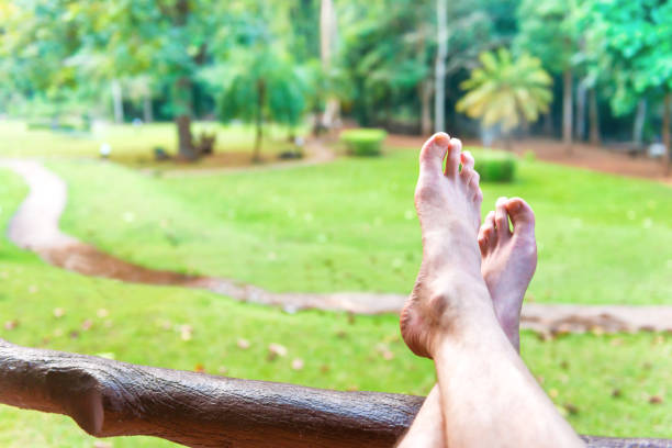 gołe stopy odpoczywającego człowieka na zielonym tle trawnika - travel travel locations nature erawan zdjęcia i obrazy z banku zdjęć