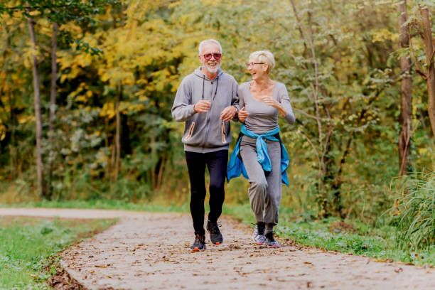 istock Smiling senior couple jogging in the park 1249855204