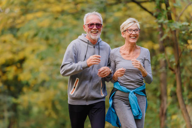 istock Smiling senior couple jogging in the park 1249855217