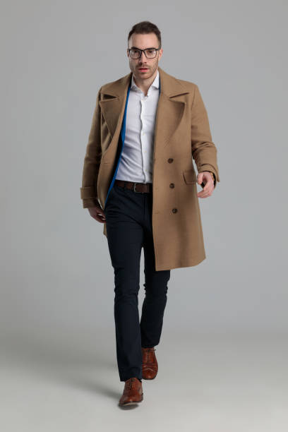istock sexy smartcasual guy wearing long coat and walking 1249855265
