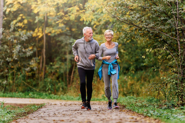 istock Smiling senior couple jogging in the park 1249855955