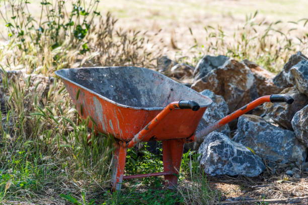 istock Orange colored old wheelbarrow in the garden 1249856370