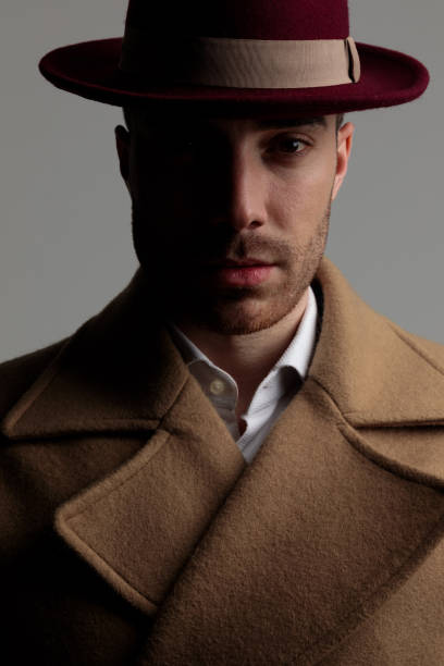 istock young smartcasual man wearing hat and long coat 1249856375