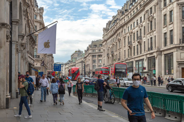 Customers queue at Apple's Regent Street Store Customers queue at Apple's Regent Street Store as the UK's Coronavirus (SARS-CoV-2) restrictions are lifted. London, England - 15 June 2020 facade store old built structure stock pictures, royalty-free photos & images