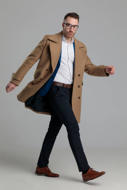 istock attractive smartcasual guy wearing long coat walking 1249856575
