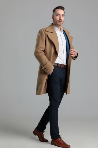 istock confident young smartcasual guy in longcoat walking 1249856649
