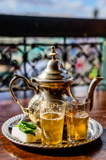 um bule de chá de hortelã em um dos muitos cafés na praça jemaa el fnaa em marrakech, marrocos. - mint tea - fotografias e filmes do acervo