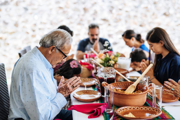 istock Multi generation Latin American family praying before lunch 1249858633
