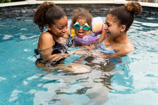 istock Mixed-race sisters having fun in the backyard pool. 1249864209