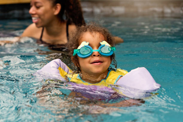 istock Mixed-race sisters having fun in the backyard pool. 1249864298
