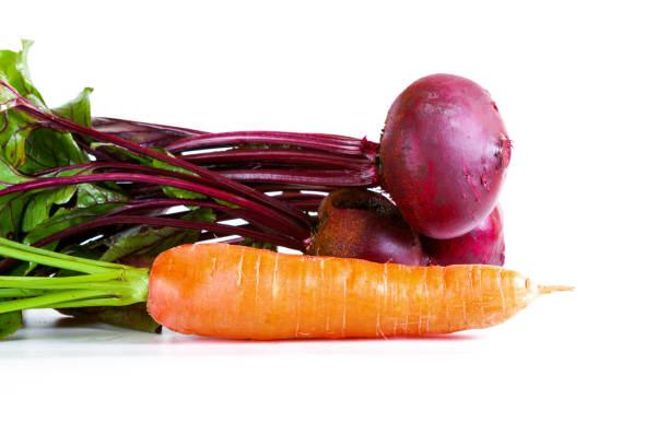 Studio shot of purple carrots cut out against a white background.