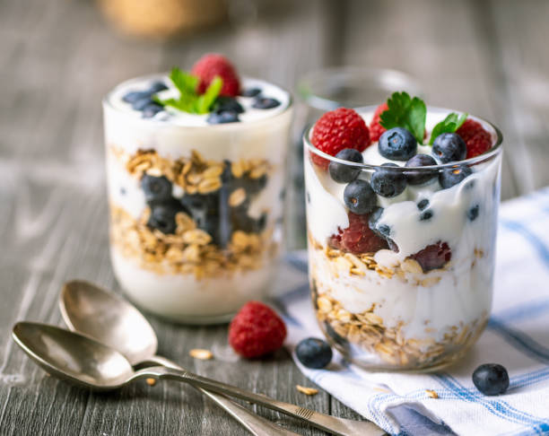 istock White yogurt in glass jar with fruits on grey background. 1249867456