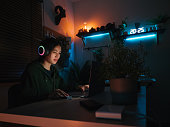 Young man playing video game inside a room at home.