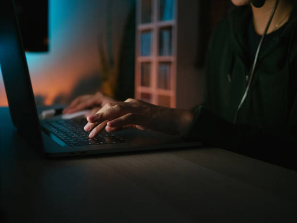 istock Young girl playing computer game on laptop at night 1249868550