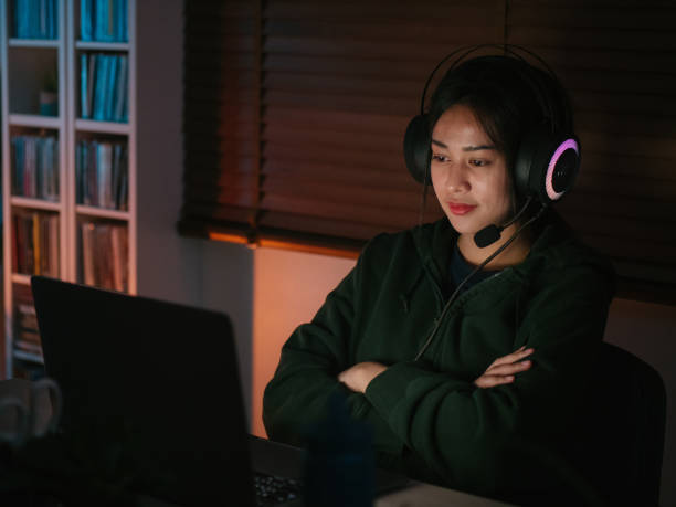 istock Young girl playing computer game on laptop at night 1249868582