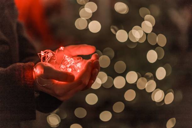 istock Garlands in the palms. Christmas lights in the hands. 1249869166