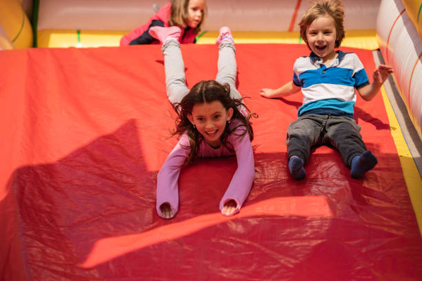 gosses heureux ayant l’amusement sur le terrain de jeu - inflatable child playground leisure games photos et images de collection