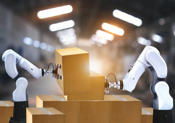 istock Robotic arms carries cardboard box 1249871201