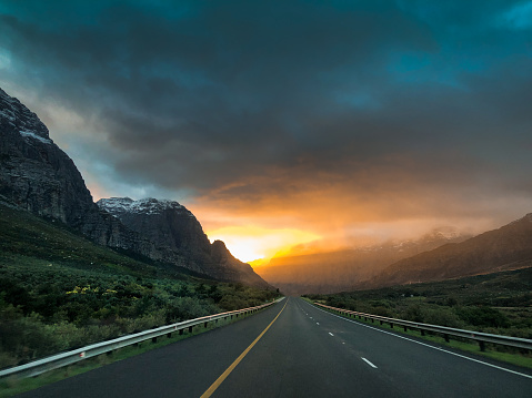 Rising Sun Breaking Through Stormy Snowcapped Mountain skies and open roads Du Toitskloof, Western Cape Province, between Paarl and Worcester South Africa