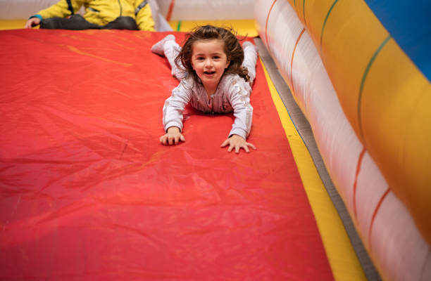 istock Little girl is sliding on inflatable castle 1249872135