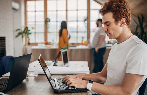 istock Redhead man working on laptop in office 1249874269