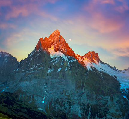 mountain slopes of Chamonix in the Alps are beautiful with a toothy panorama of mountain peaks and grassy moChamonix mountains in the Alps are beautiful with a toothy panorama of the mountain peaks of the night at moonrise and stars. Below illuminates the illumination of cities and villages