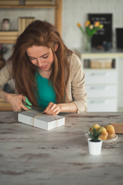 istock Excited young woman opening a package she got in a mail 1249877604