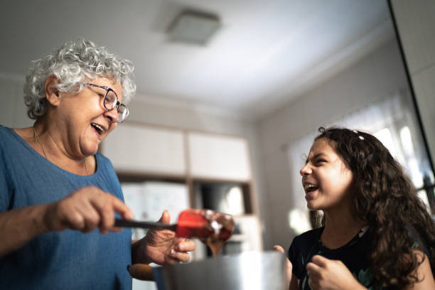 grandmother making chocolate with granddaughter at home - grandmother cooking baking family imagens e fotografias de stock