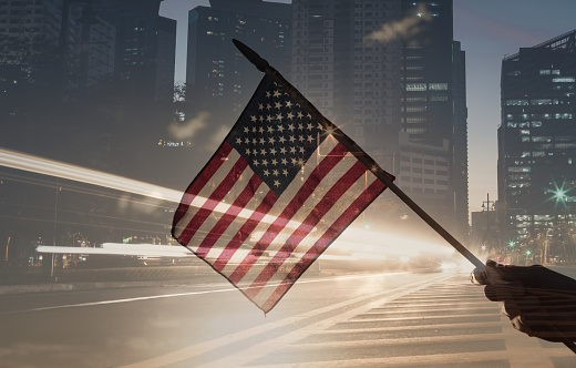 American flag on modern city background. Double exposure