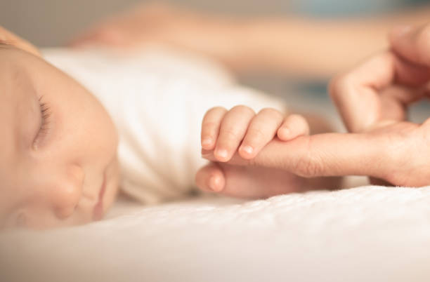 little tinny newborn baby's hand, fingers holding onto mother's hand. - newborn human hand baby father imagens e fotografias de stock