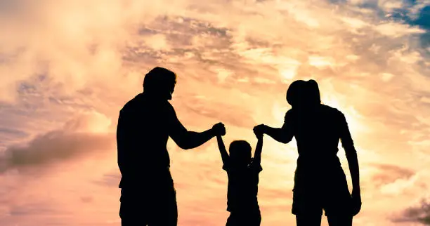 Photo of Family playing at sunset.