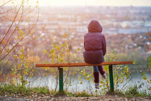 jovem mulher sentada no banco no parque da cidade de outono e olhando para a paisagem da cidade, vista para trás - bench mountain park sitting - fotografias e filmes do acervo