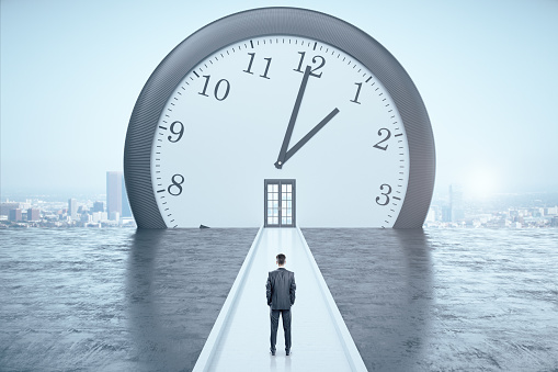 Businessman looking on clock with door on a megapolis city view background. Business and deadline concept.