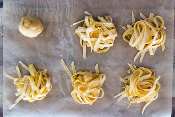 primo piano di pasta fatta in casa (fettuccine) - cooked in a row traditional culture indoors foto e immagini stock