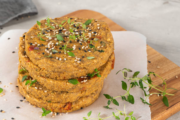 istock Raw veggie burger with lentils, vegetables and thyme leaves on kitchen countertop. 1249882595