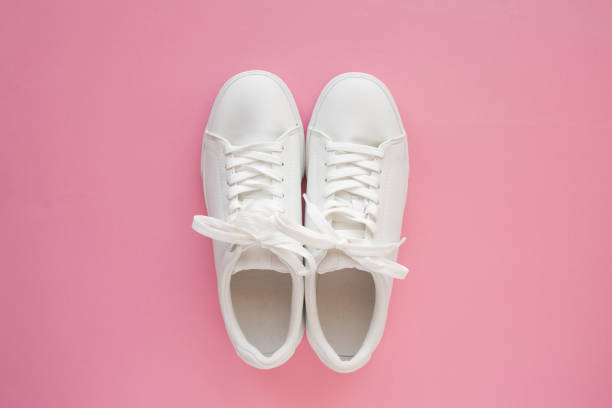 istock Perfect white New sneakers standing on a bright pink background. 1249882652