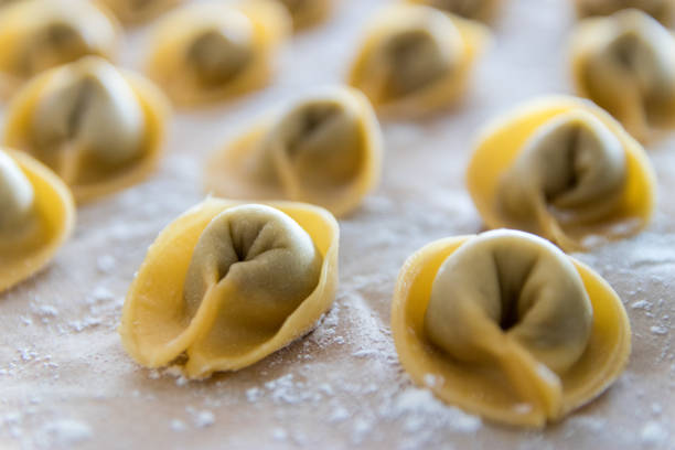 primo piano di pasta fatta in casa (tortellini) - cooked in a row traditional culture indoors foto e immagini stock