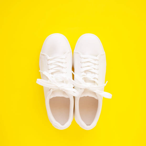 istock Perfect white New sneakers standing on a bright yellow background. 1249882723