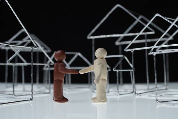istock Black man and white man figurines shake hands 1249883892