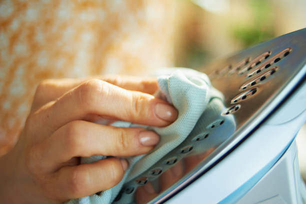 istock Closeup on woman cleaning iron with cloth 1249884572