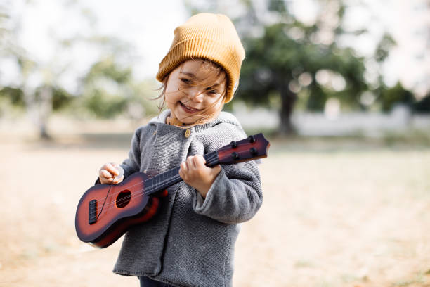 istock Litlle girl playing guitar 1249889817