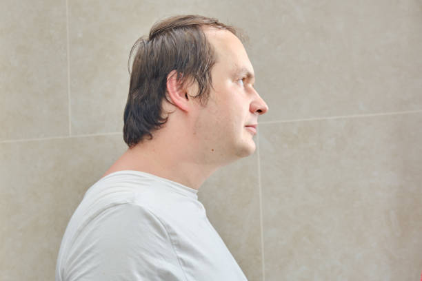 retrato de un hombre con una camiseta blanca, de cerca. cara de un hombre de 35-40 años de edad en el perfil sobre un fondo beige - 35 40 years fotografías e imágenes de stock